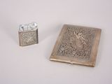 a silver lighter and a book on a white table