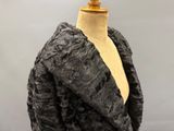 black fur coat on a mannequin mannequin with a wooden base