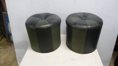 une paire de tabourets en cuir noir et vert posés sur une table blanche