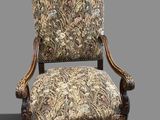 an old chair with a floral upholstered back and arms