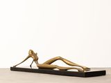 bronze sculpture of a woman laying on a black base