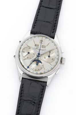 a close up of a watch on a white surface with a black strap