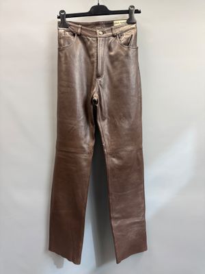 a pair of brown leather pants hanging on a hanger