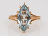 a close up of a gold ring with a blue topaz stone