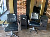 three black chairs in a room with a brick wall