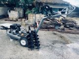 a machine that is sitting on the ground next to a pile of wood