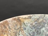 a close up of a stone bowl on a table