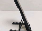 a close up of a cell phone on a stand on a table