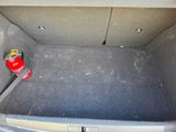 a red fire hydrant sitting in the trunk of a car