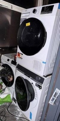 une pile de machines à laver et un sèche-linge dans une pièce