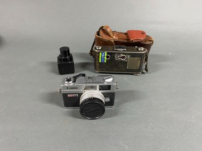 a small camera sitting on a table next to a brown bag