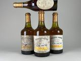 trois bouteilles de vin empilées les unes sur les autres à côté d'une bouteille de vin