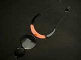 un collier noir et orange posé sur une surface noire