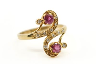 gros plan d'une bague en or avec deux rubis