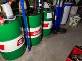 three green barrels sitting next to each other in a garage
