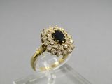 a close up of a gold ring with a black stone surrounded by white diamonds