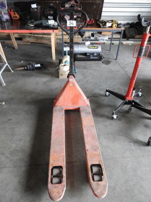 a forklift in a garage with other tools in the background