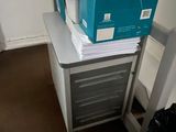 a stack of papers sitting on top of a filing cabinet