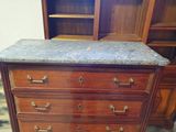 a marble top chest of drawers in a room