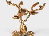 brass figurine of a flower with leaves on a white background