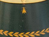 a green and gold lamp with a bird on top of it