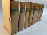 six books are lined up in a row on a white surface
