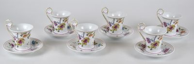 six tasses et soucoupes ornées de fleurs, posées sur une table