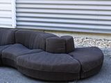 an image of a black couch in a parking lot