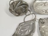 four pieces of silverware are sitting on a white surface
