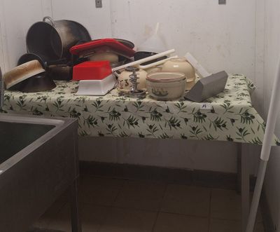 une table sur laquelle sont posés tout un tas de casseroles et de poêles