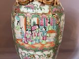 a vase with a painting on it sitting on a table