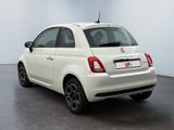 the back of a white fiat car is parked in a room