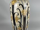 a vase with a floral design on it sitting on a table
