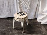 a white chair sitting in front of a white curtain