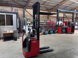 un chariot élévateur rouge dans un entrepôt rempli d'étagères