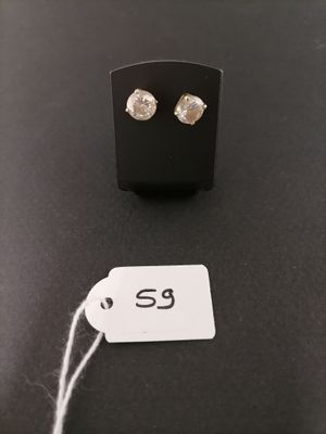 a pair of earrings on a table with a price tag