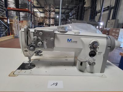 a white sewing machine sitting on a table in a warehouse