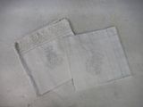 two white towels on a table with a white table cloth