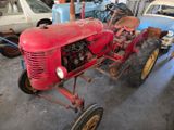 a red tractor that is parked in a garage