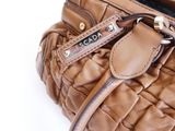 brown leather handbag on a white background with a name tag on it