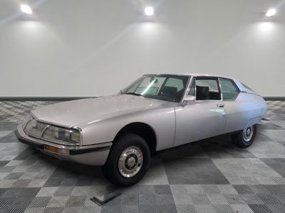 a silver car that is parked on a checkered floor