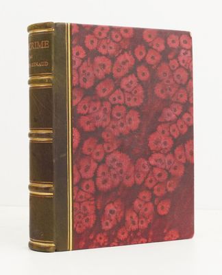an old book with red flowers on it sitting on a white surface