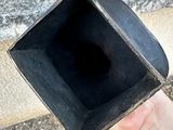a person holding a black square object in their hand
