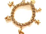 une image représentant un bracelet en or orné de breloques sur fond blanc