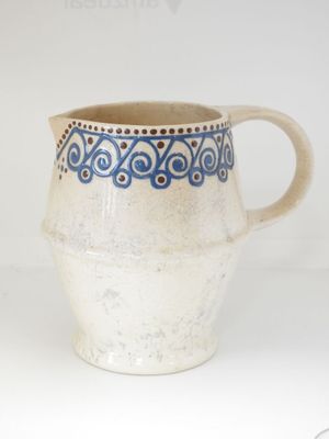 a blue and white pitcher sitting on a white table