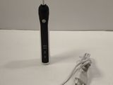 une photo représentant une brosse à dents et un chargeur posés sur une table