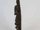 statue of a man holding a surfboard on a black stand