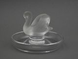 un cygne en verre posé sur une assiette en verre