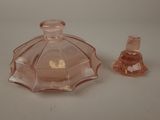 a small pink glass bottle and a small pink glass candle holder