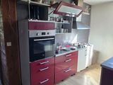 une image d'une cuisine avec une cuisinière et un réfrigérateur